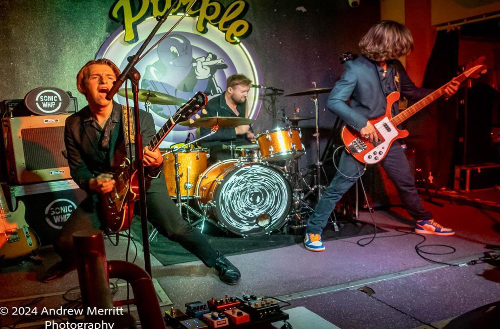 three piece band performing on stage at the Purple Turtle
