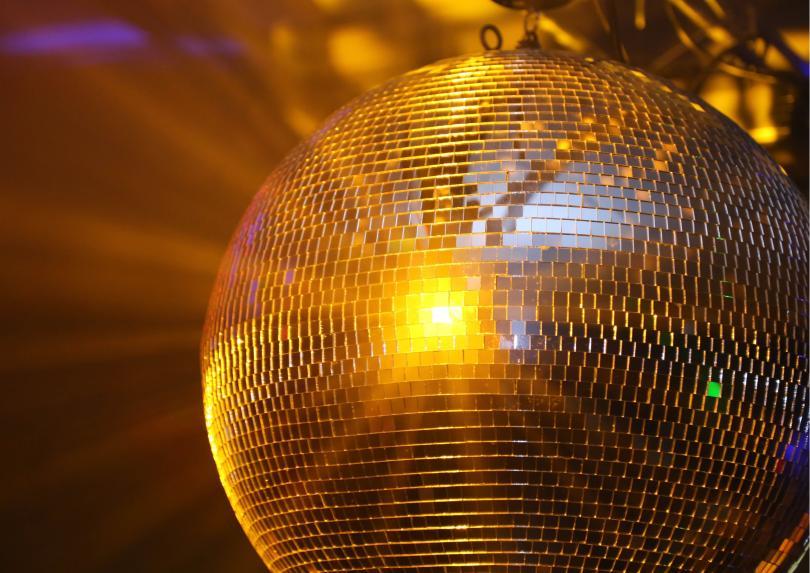 Glitter ball hanging, with gold light flashing lights onto surroundings