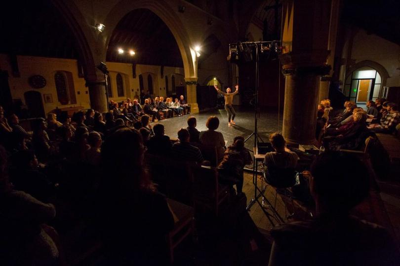 A full-house audience watching a dancer
