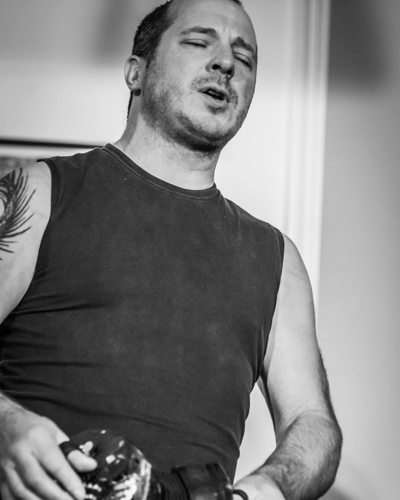 Black and white image of Damien Barber singing and playing concertina