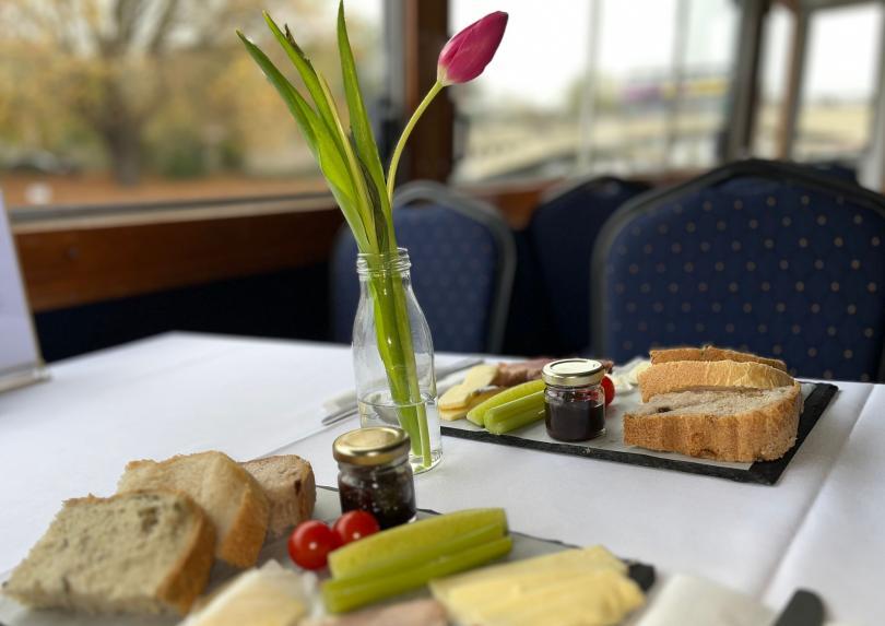 table for 2 set with tulips in vase, each with own ploughmans type lunch