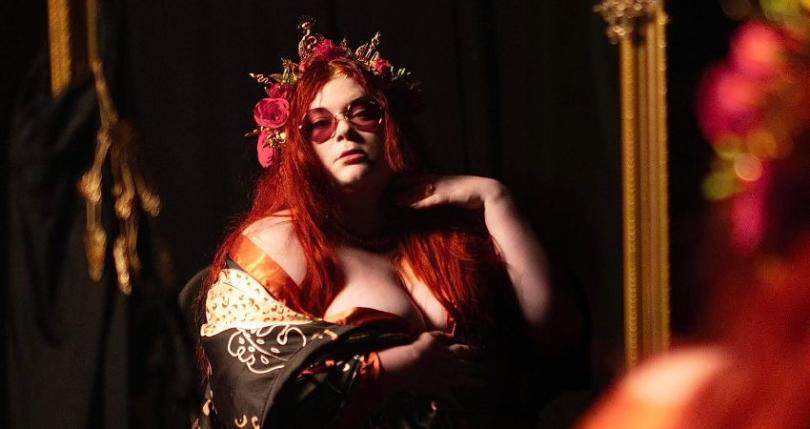 Photo of Alice Armstrong with red hair and black glasses