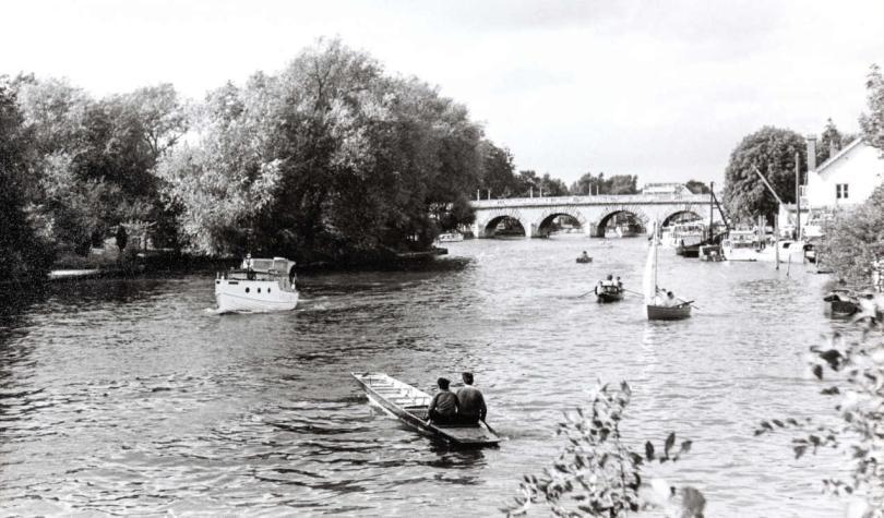 Scene of boats on the River Thames with bridge in the distance