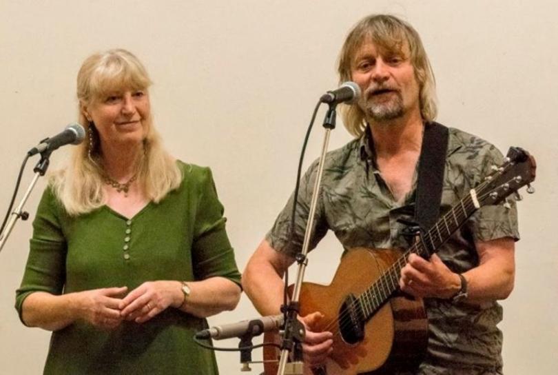 Jeff & Elaine Gillett performing together. Elaine is singing and Jeff is playing guitar.