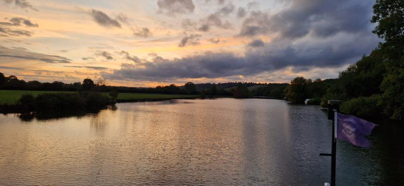 Thames rivercruise boat flag seen and sunset on the river thames