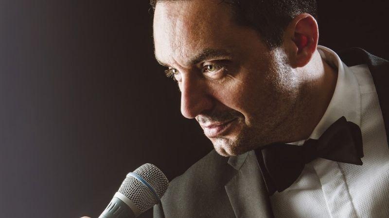The image shows a close up of a Michael Buble tribute artist singing into a microphone.