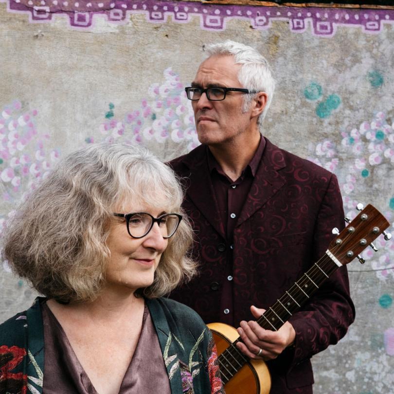 Photo of the duo Milton Hide.  Jim Tipler and Jo Church are posing for the photograph with Jim holding a guitar.