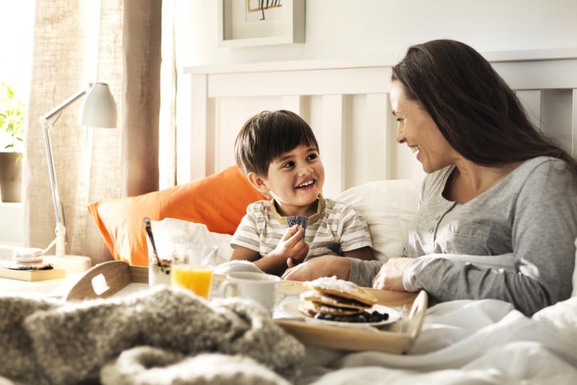 Mother and son having breakfast in bed 
