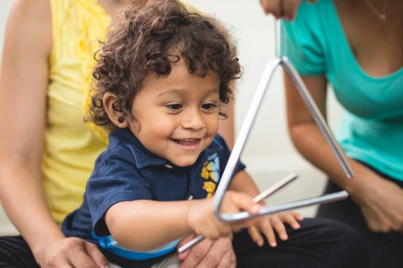 Child playing triangle
