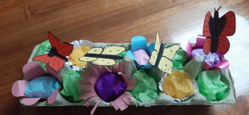 Photograph of an egg box filled with handmade crafted flowers