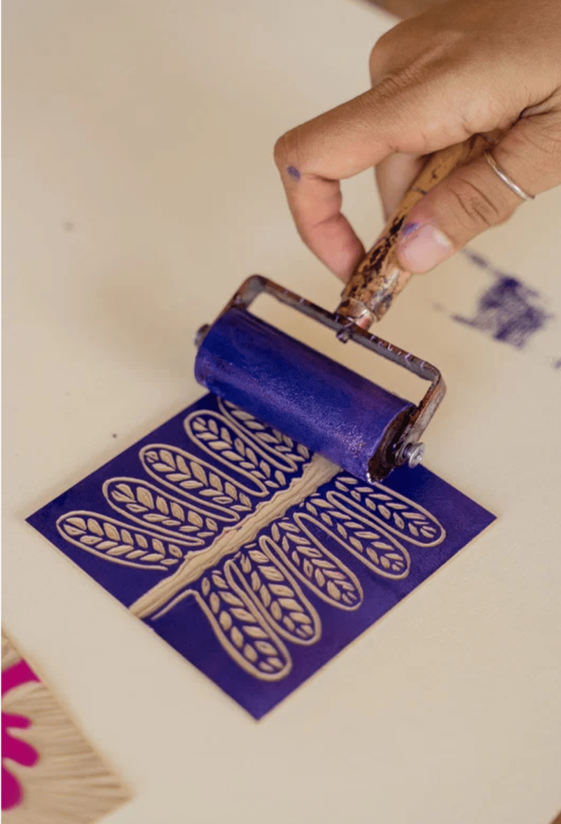 Hand using a linocut printing roll