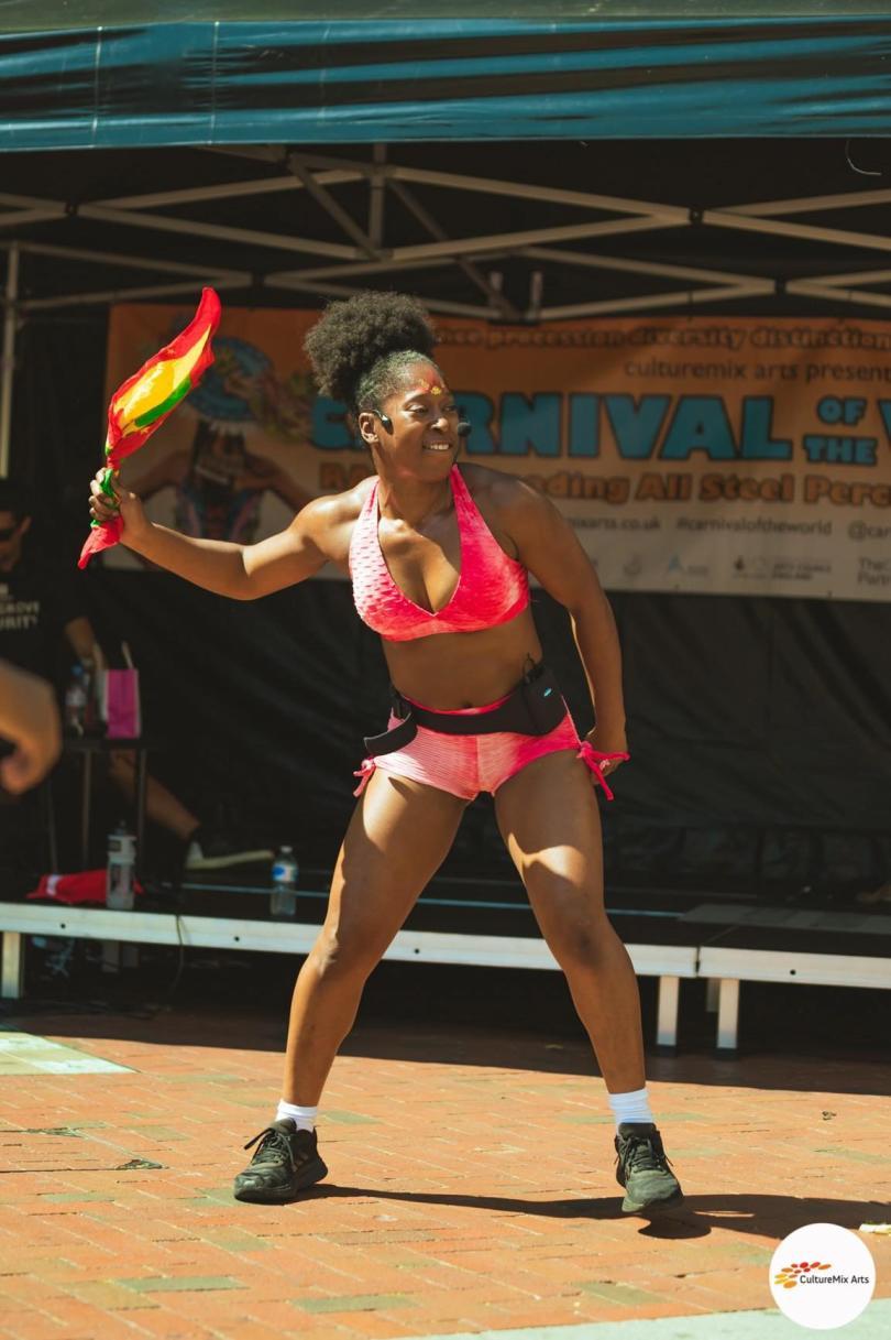 Soca dance class tutor Krystle waving a flag at a dance workshop 