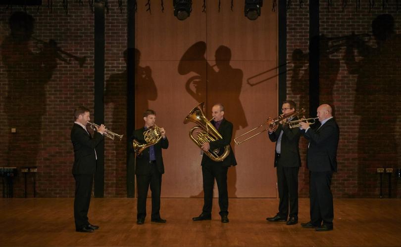 Onyx Brass standing in a semi circle playing