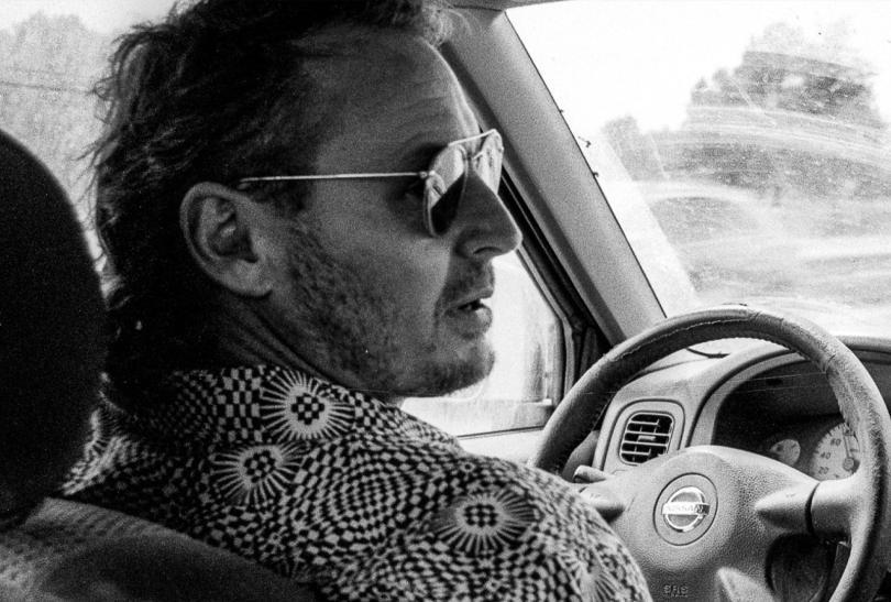 Singer Ben Howard wearing sunglasses at the wheel of a car