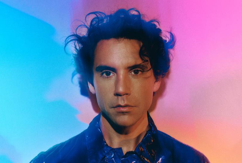 Singer Mika against a pink and blue background