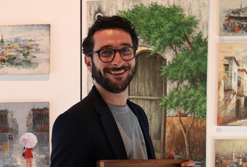 Artist Ahmad Alazami surrounded by his paintings