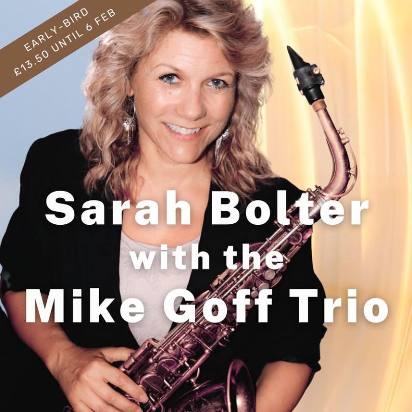 Female saxophonist with blonde hair and a black jacket