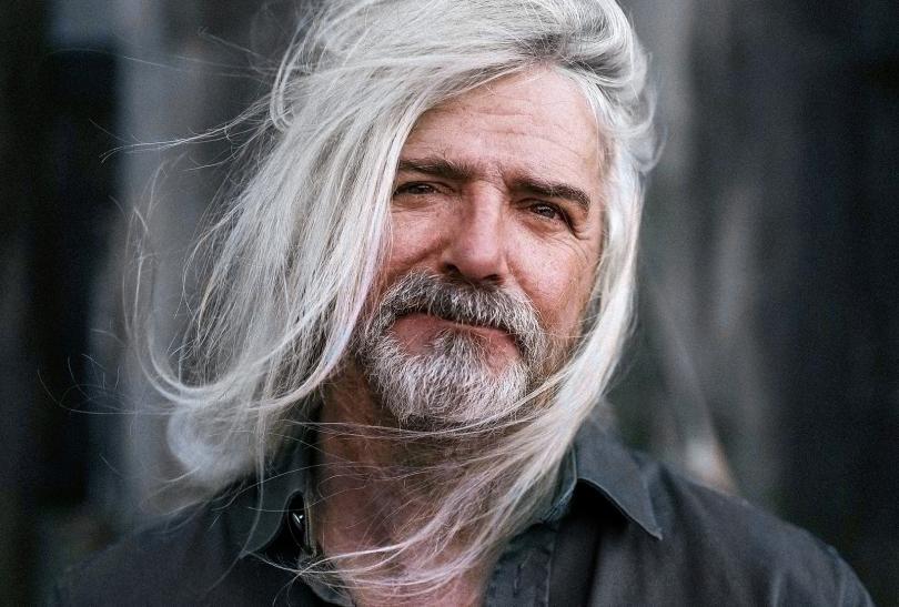 John Bramwell with long white windswept hair and a greying beard
