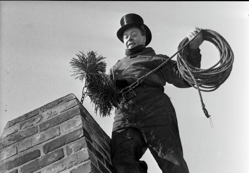 chimney sweep on the top of a roof