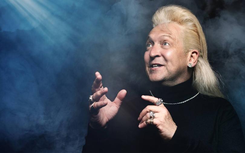 Clinton baptiste, with a bleach blonde mullet, holding a microphone