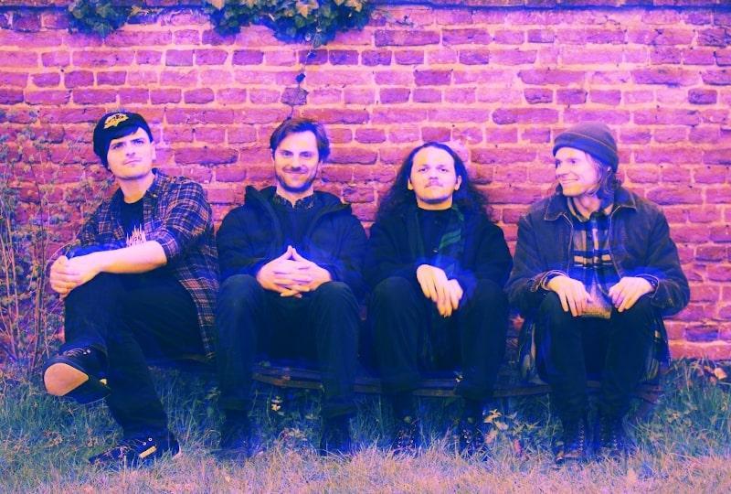 doops band sitting in front of a wall