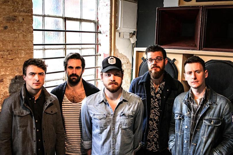 five beared men in denim shirts and leather jackets