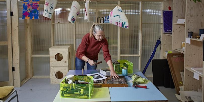 artist using printmaking tools in the studio