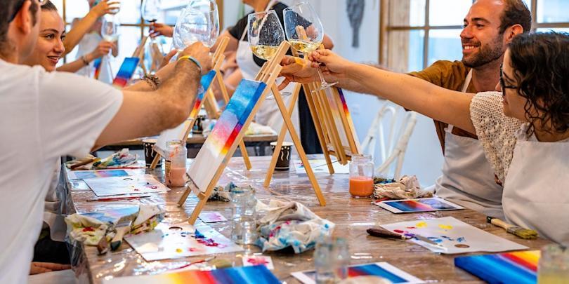 An art class cheers-ing glasses of prosecco