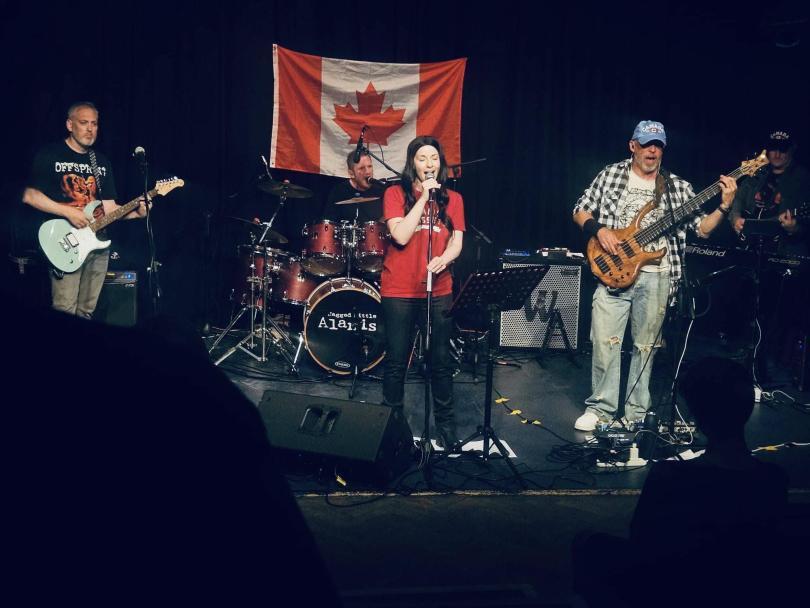 Jagged Little Alanis band on stage in front of a Canadian flag