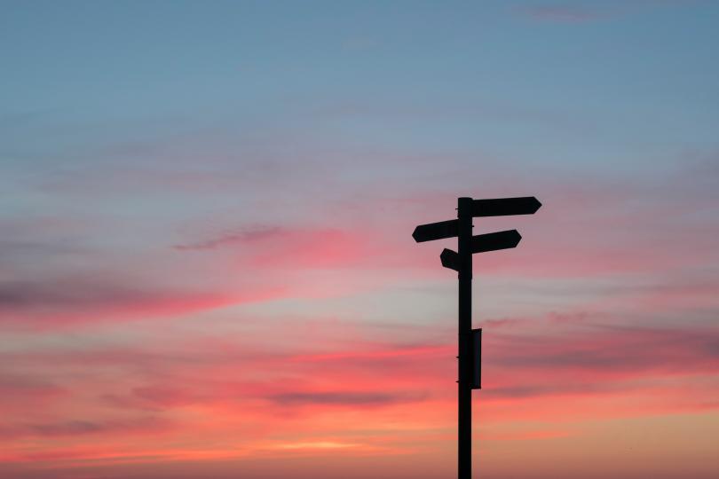 A signpost against a sunset