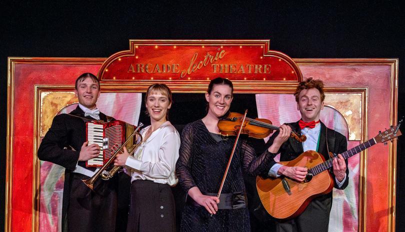 four actor-musicians in smart dress holding musical instruments in front of a painted backdrop