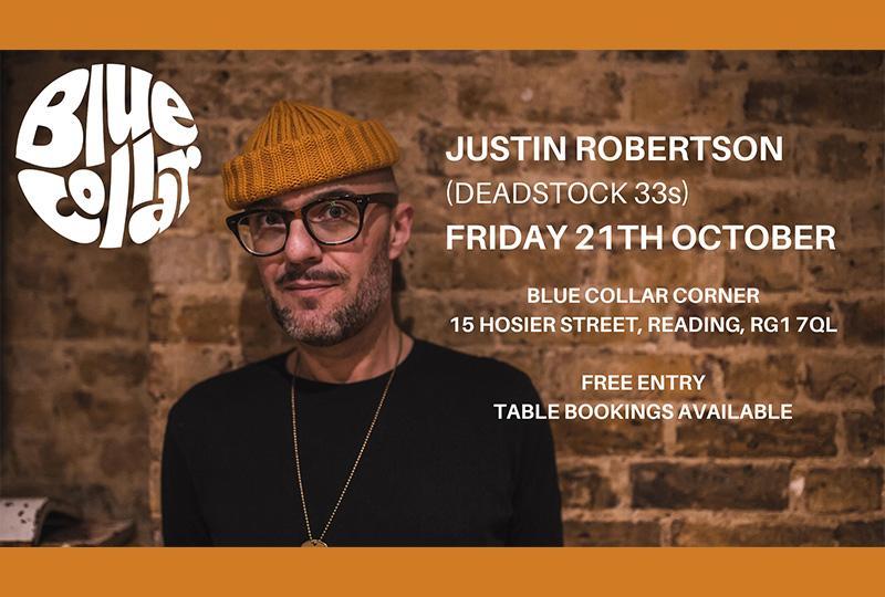 Justin Robertson in an orange wool hat against a brick wall