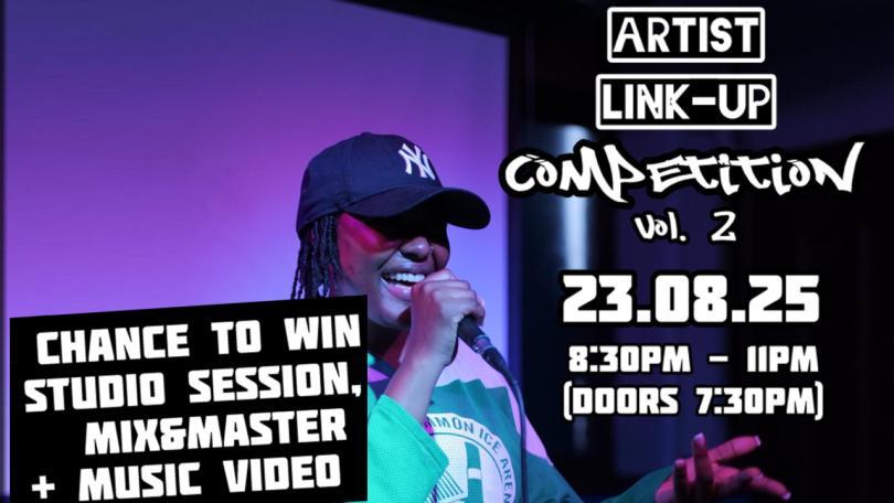 Black womand in a baseball cap singing on stage