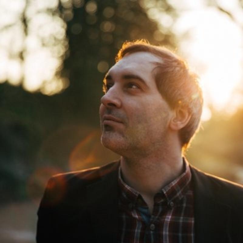 Ben Marwood stood in a wood. He has short dark hair and a checked shirt