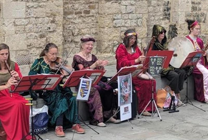 people in medieval costume playing instruments