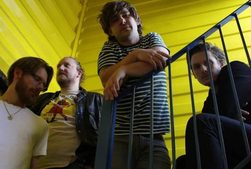 the band Mellor gathered round a stairwell in a yellow shipping container