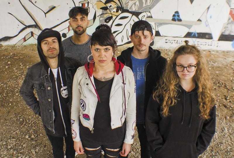 Millie Manders and The Shutup in front of graffitti