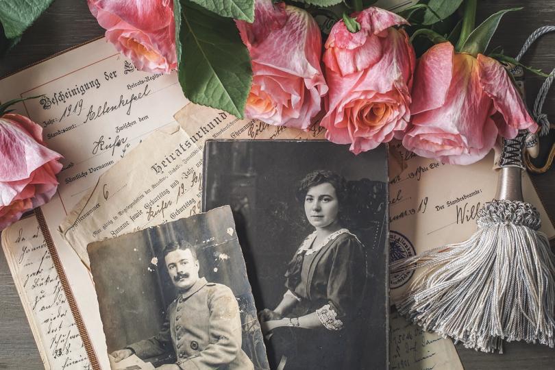 Old photos, flowers and documents on a desk