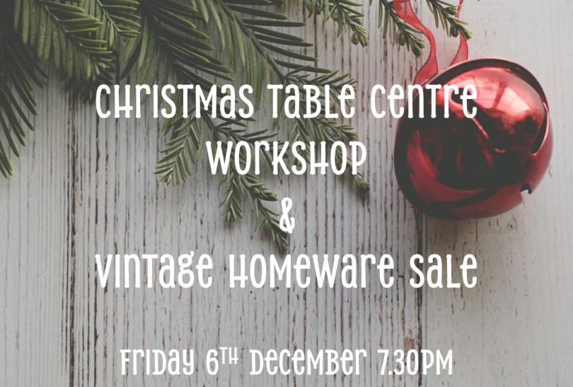 close up of a Christmas tree branch and bauble on a table