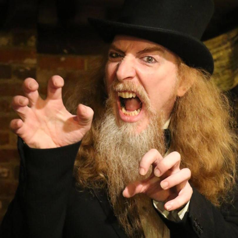 Long ginger haired gentleman with greying beard in a top hat