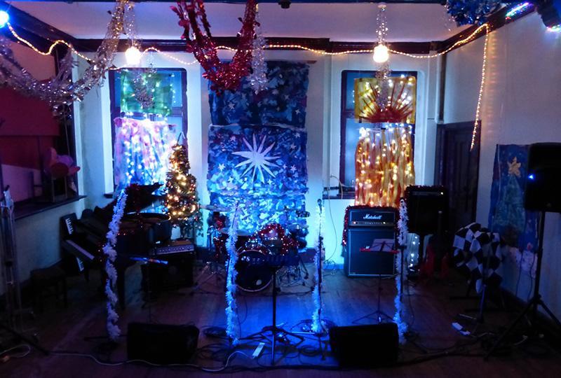 instruments and amps covered in Christmas decorations at the Rising Sun Arts Centre