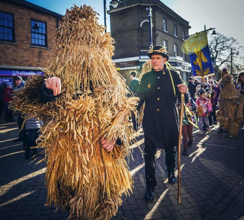 A Whittlesey Straw Bear parading down the street