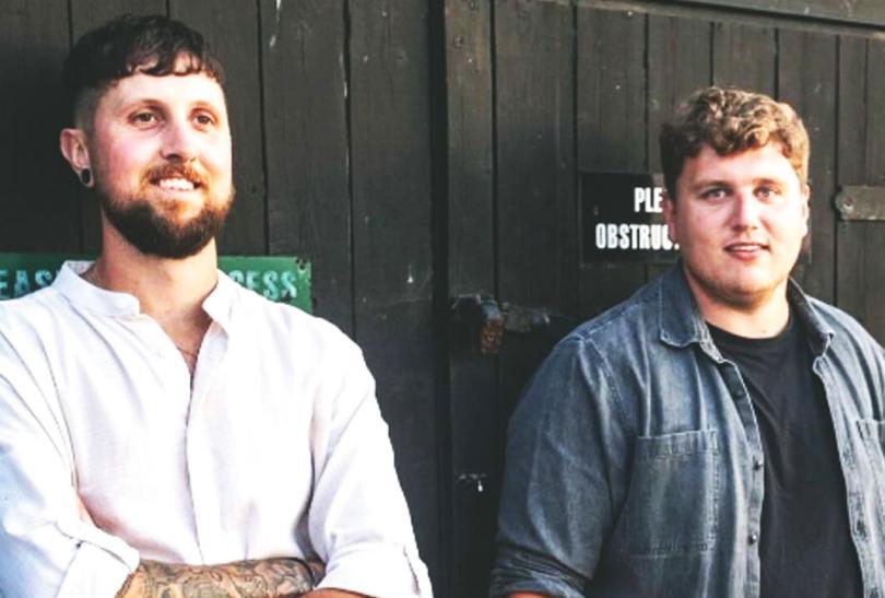 Musicians Wilswood Buoys, two white men standing against a wooden door