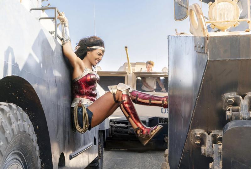 Image of Wonder Woman squeezing between two moving vehicles