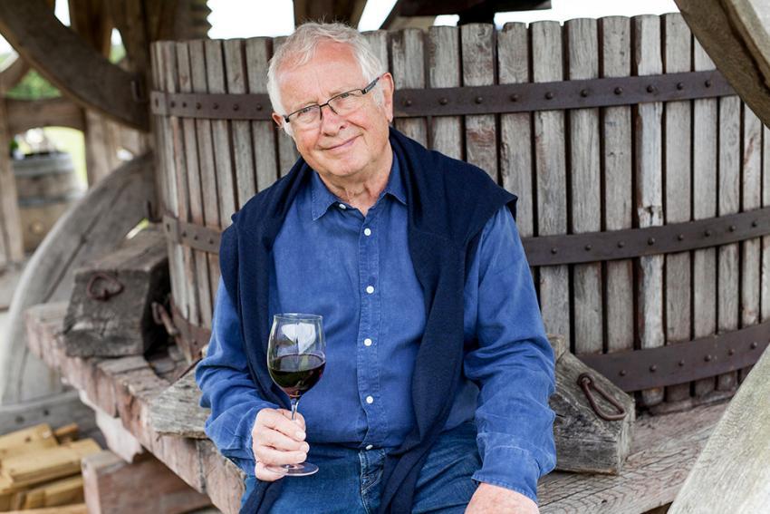 Tony Laithwaite sitting on a win press holding a glass of red