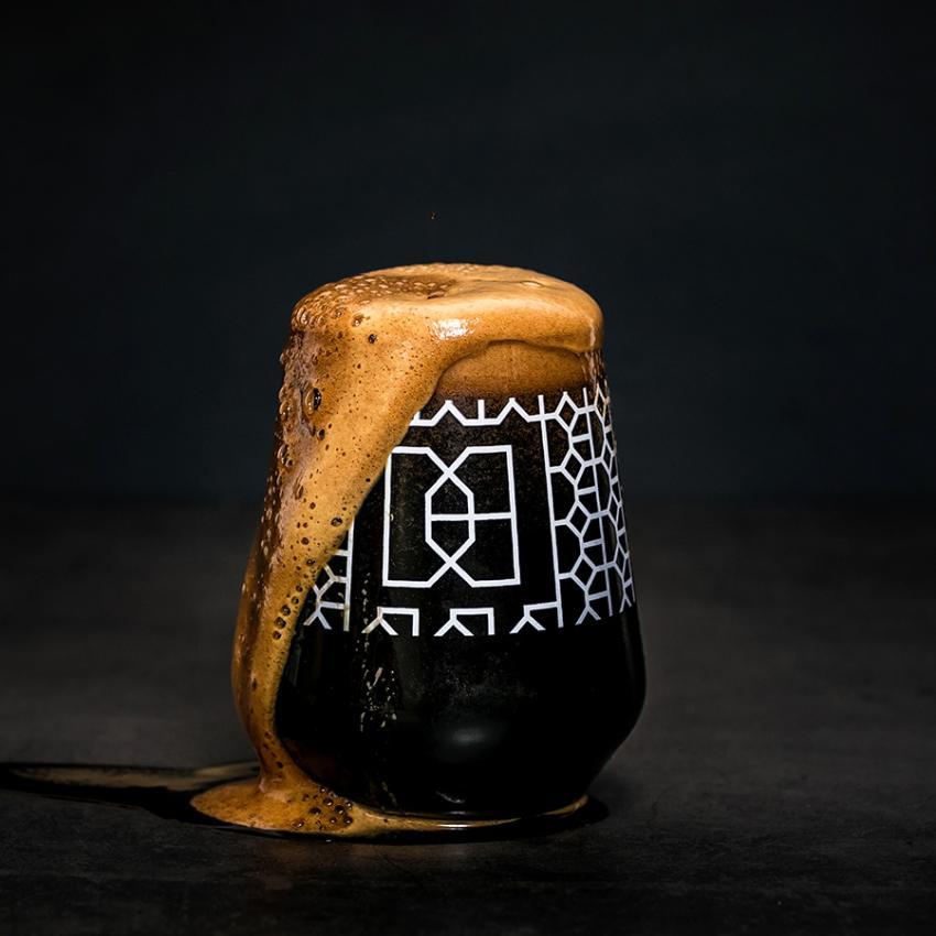 frothing glass of dark beer
