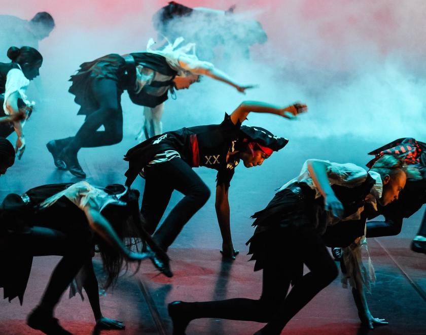 Children dressed as pirates dance on stage in a School Of The Arts performance.