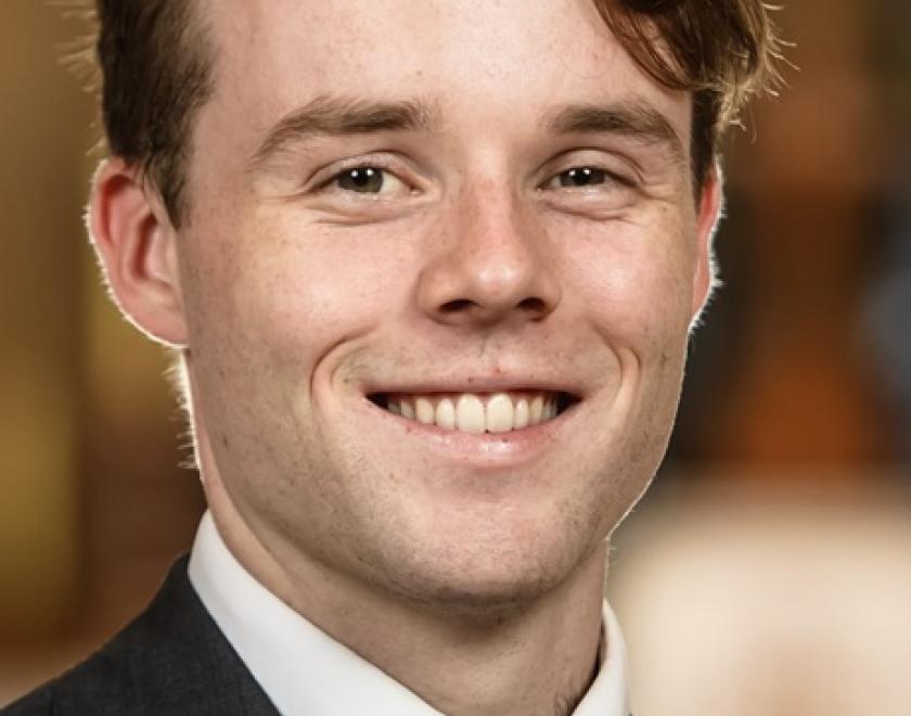 Callum Knox wearing suit a tie, smiling