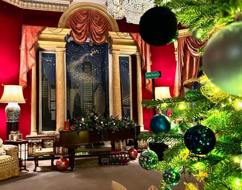 room in Basildon Park decorated with a Christmas tree and ephemera that represents the film Miracle on 34th Street