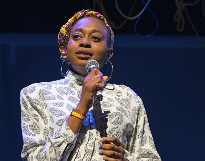 Production photo: Close-up of a  woman speaking into a microphone